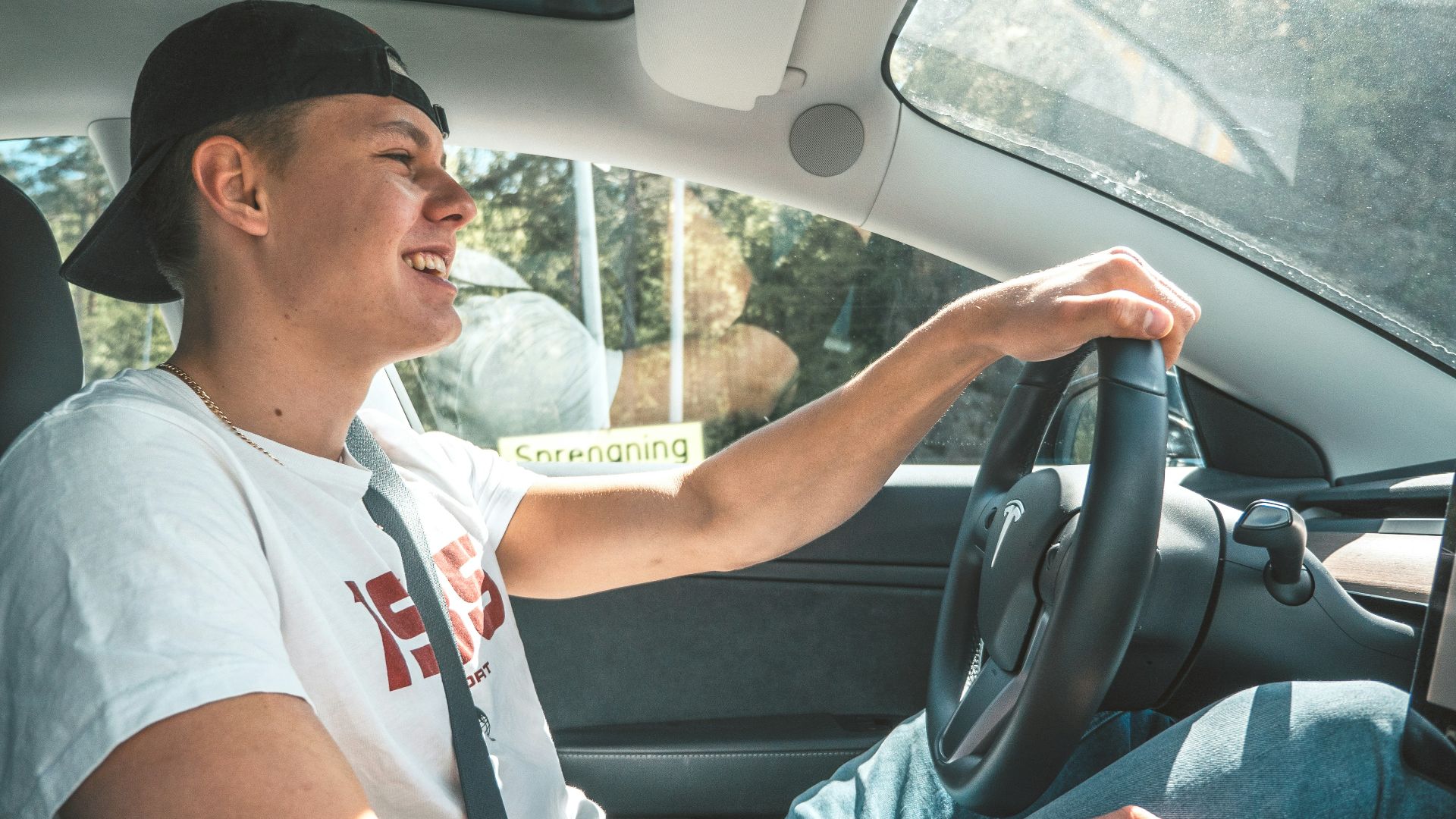 man in white crew neck t-shirt driving car