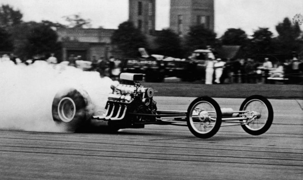 American drag racing legend Mickey Thompson (1928 - 1988) is obscured by a cloud of his own smoke as he speeds his 1,000 bhp Ford-powered dragster to a then-record-for-Europe standing quarter-mile (8.84 seconds or 178 mph), Debden RAF Station, Essex, England, January 13, 1964.