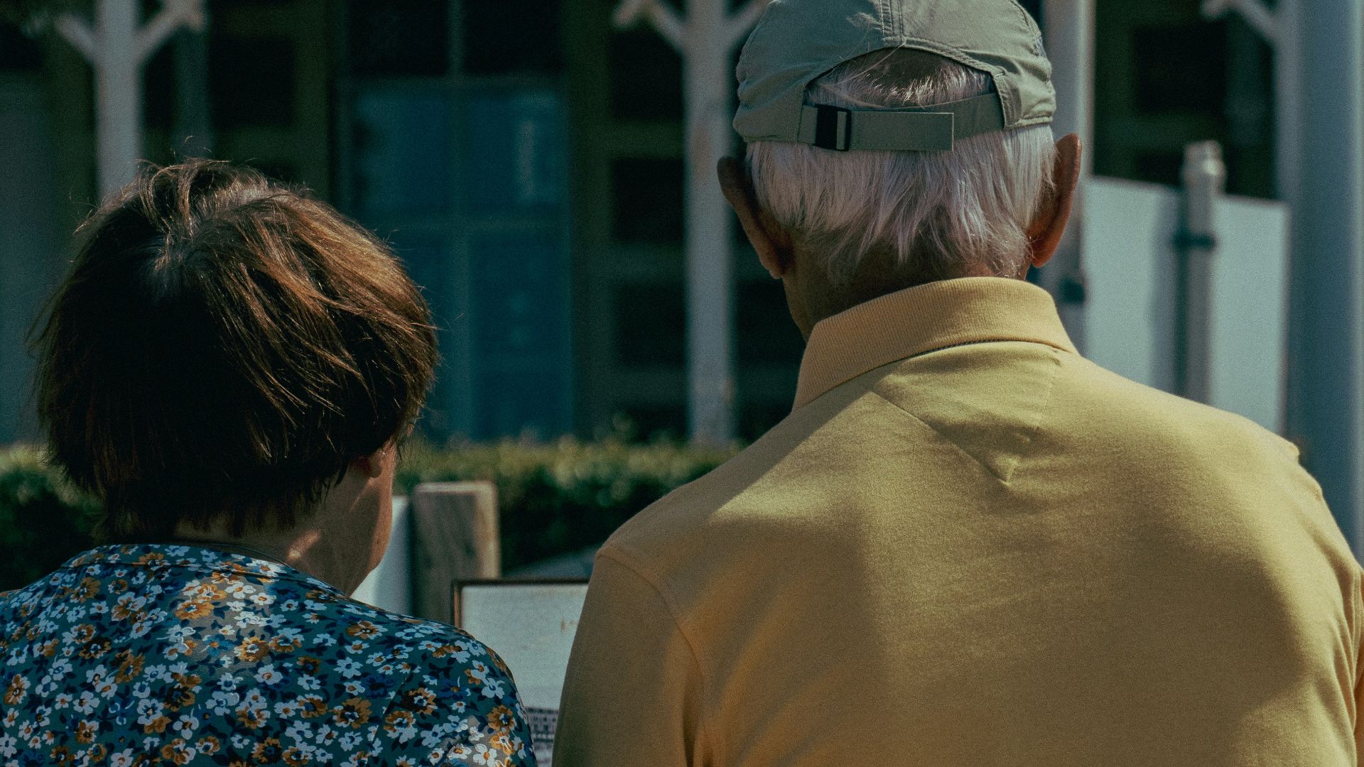 An elderly couple stands together in harmony.
