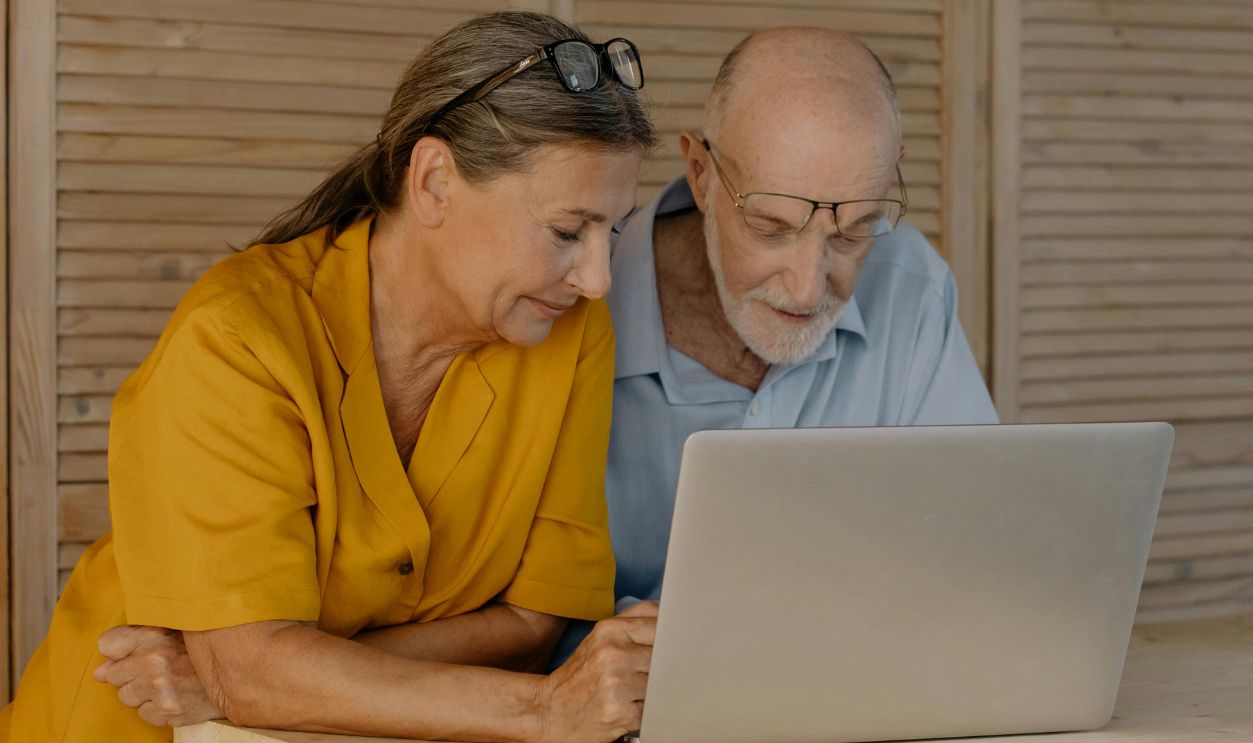 Senior couple engaged with laptop indoors, fostering connectivity and learning