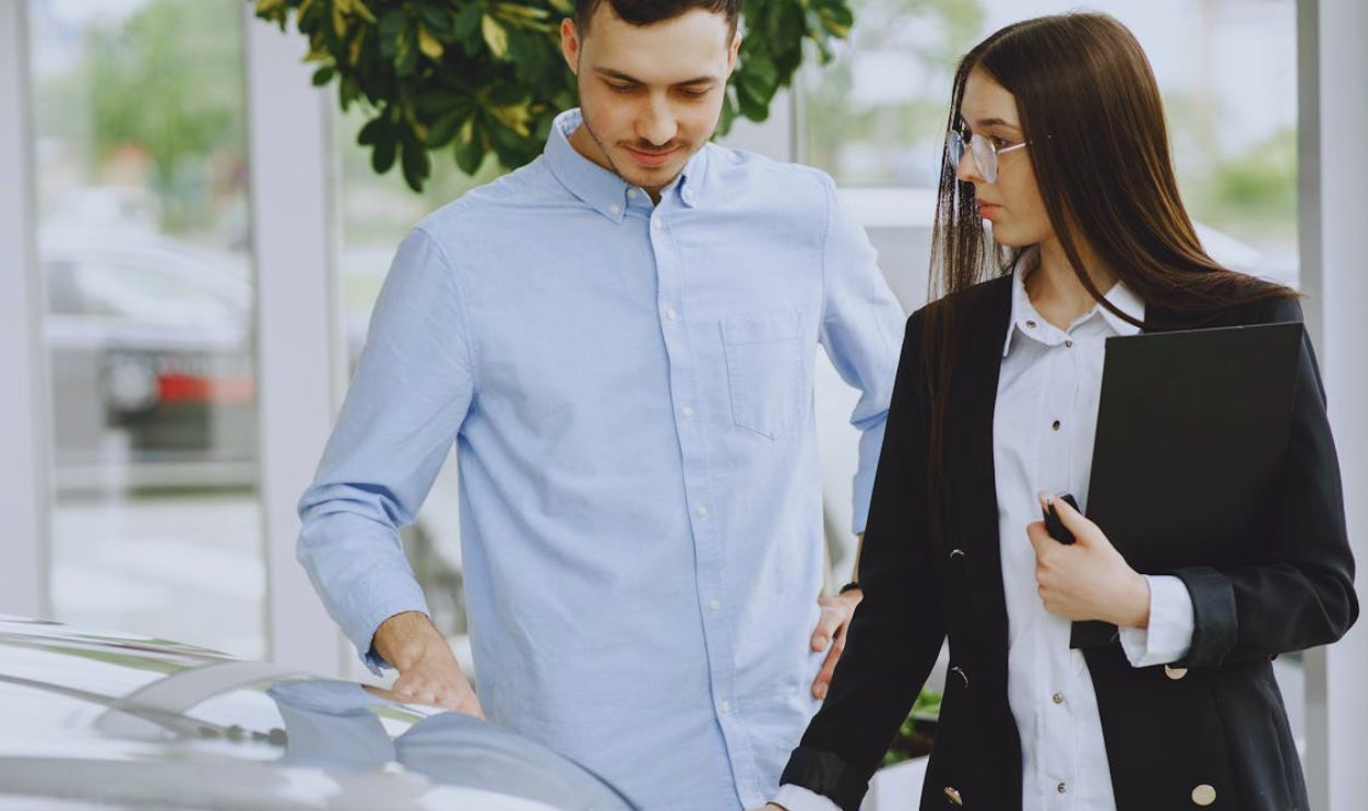 Professional interaction between a client and salesperson in a car dealership setting