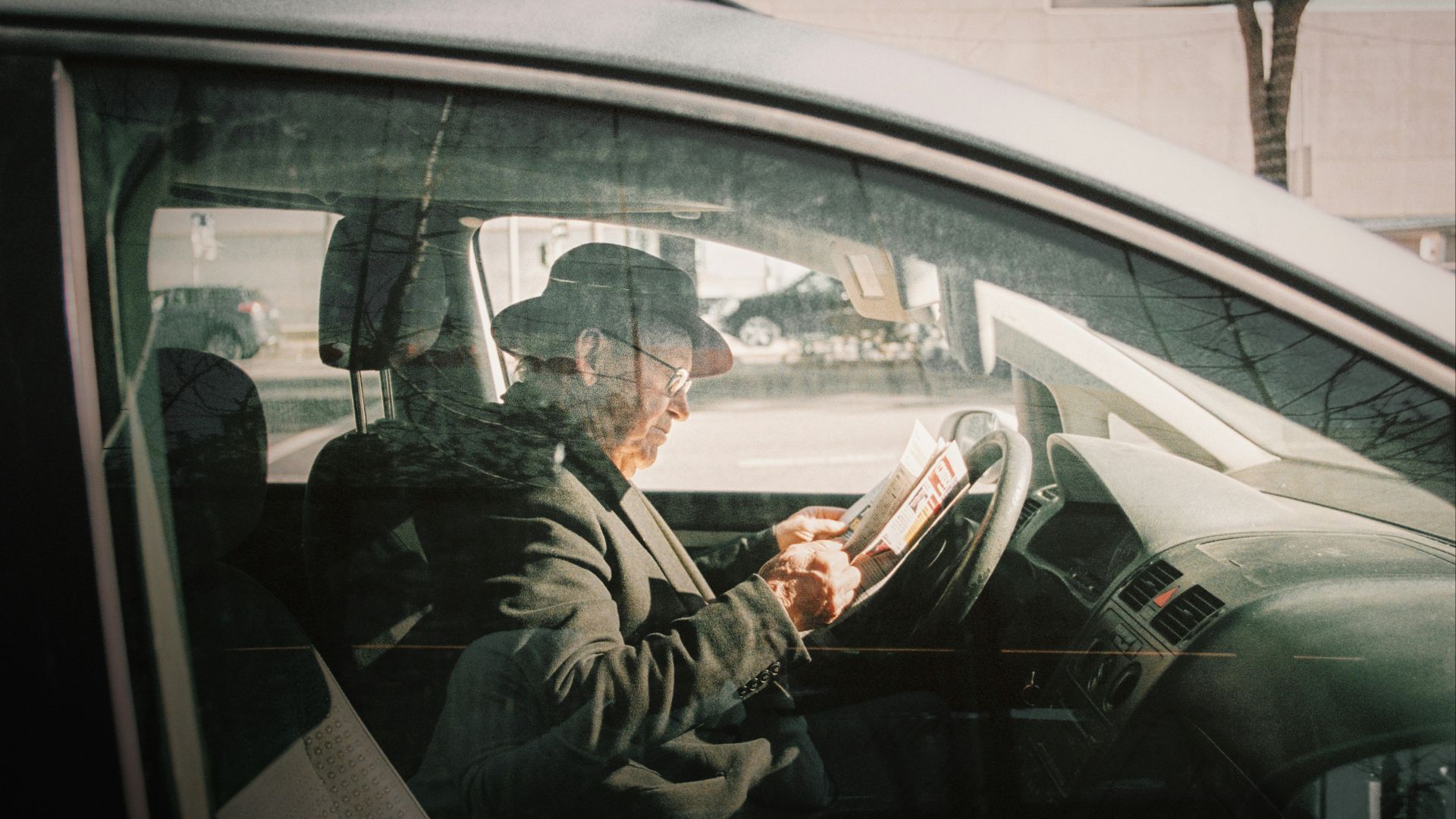man in black jacket driving car