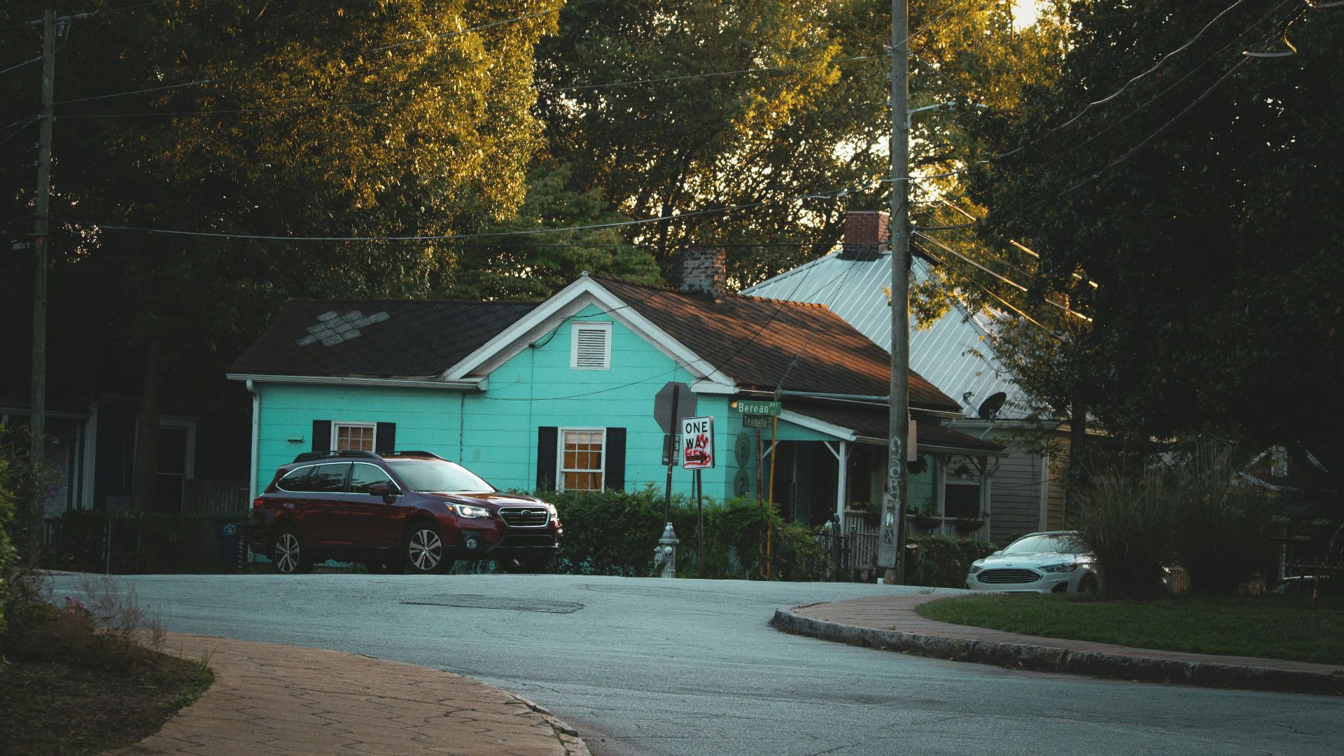 a blue house with a car parked in front of it