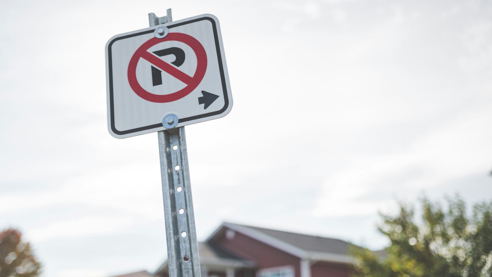 a no parking sign in front of a house