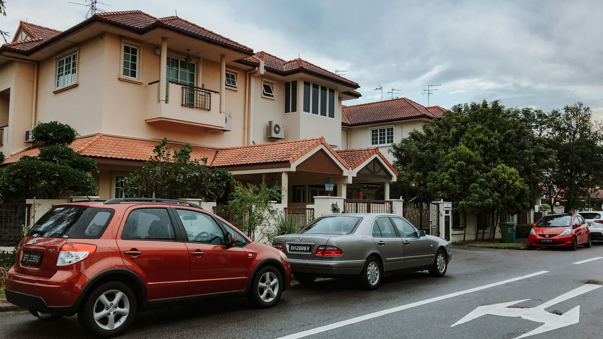 two red and gray vehicles parked beside house