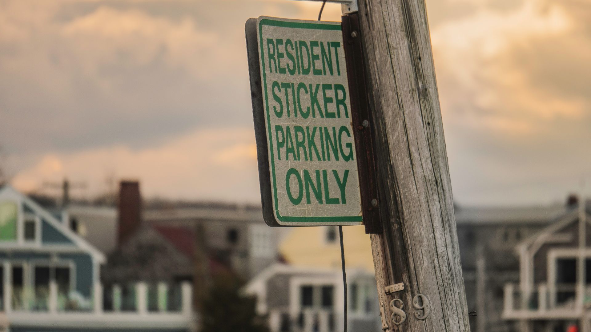 a residential sticker parking only sign on a telephone pole