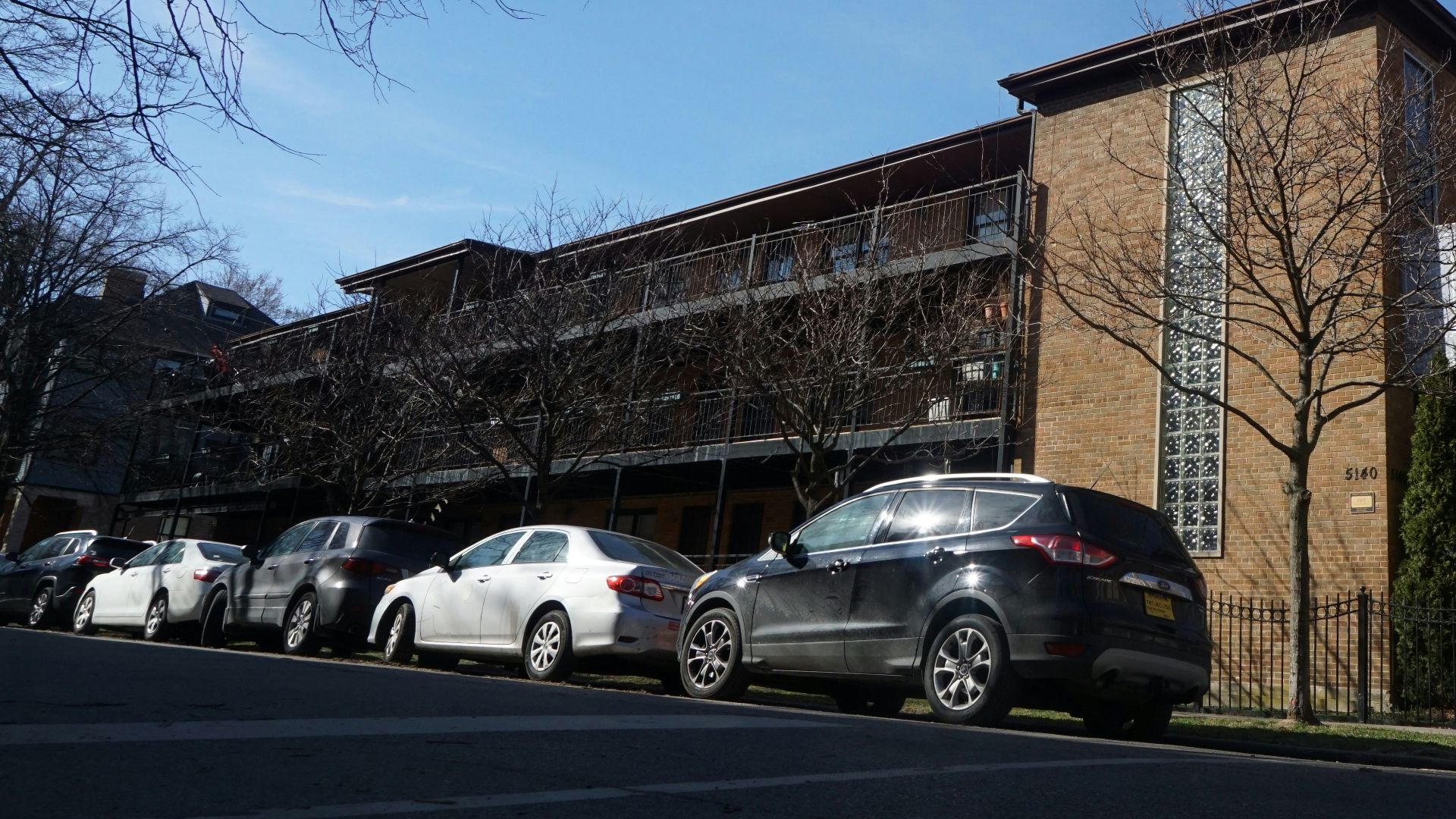 Apartment building with cars parked on street