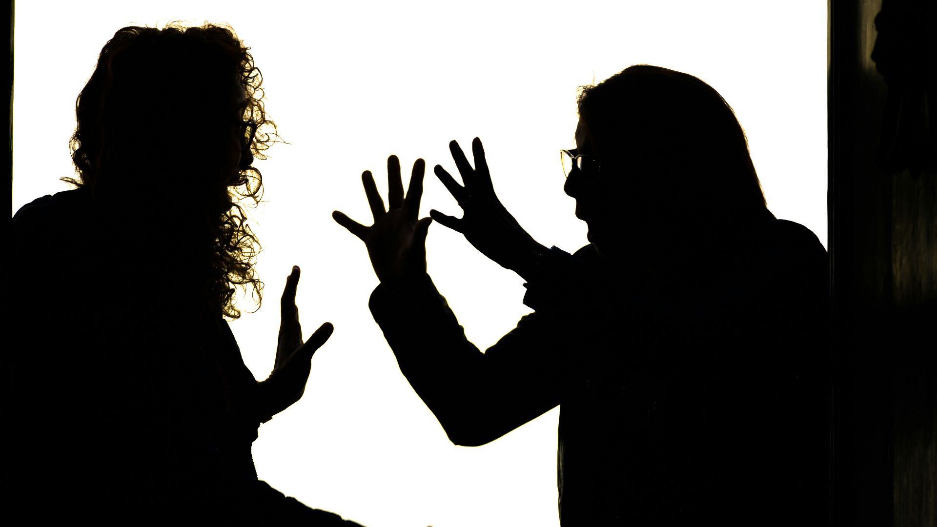 Silhouetted figures engage in a heated argument.