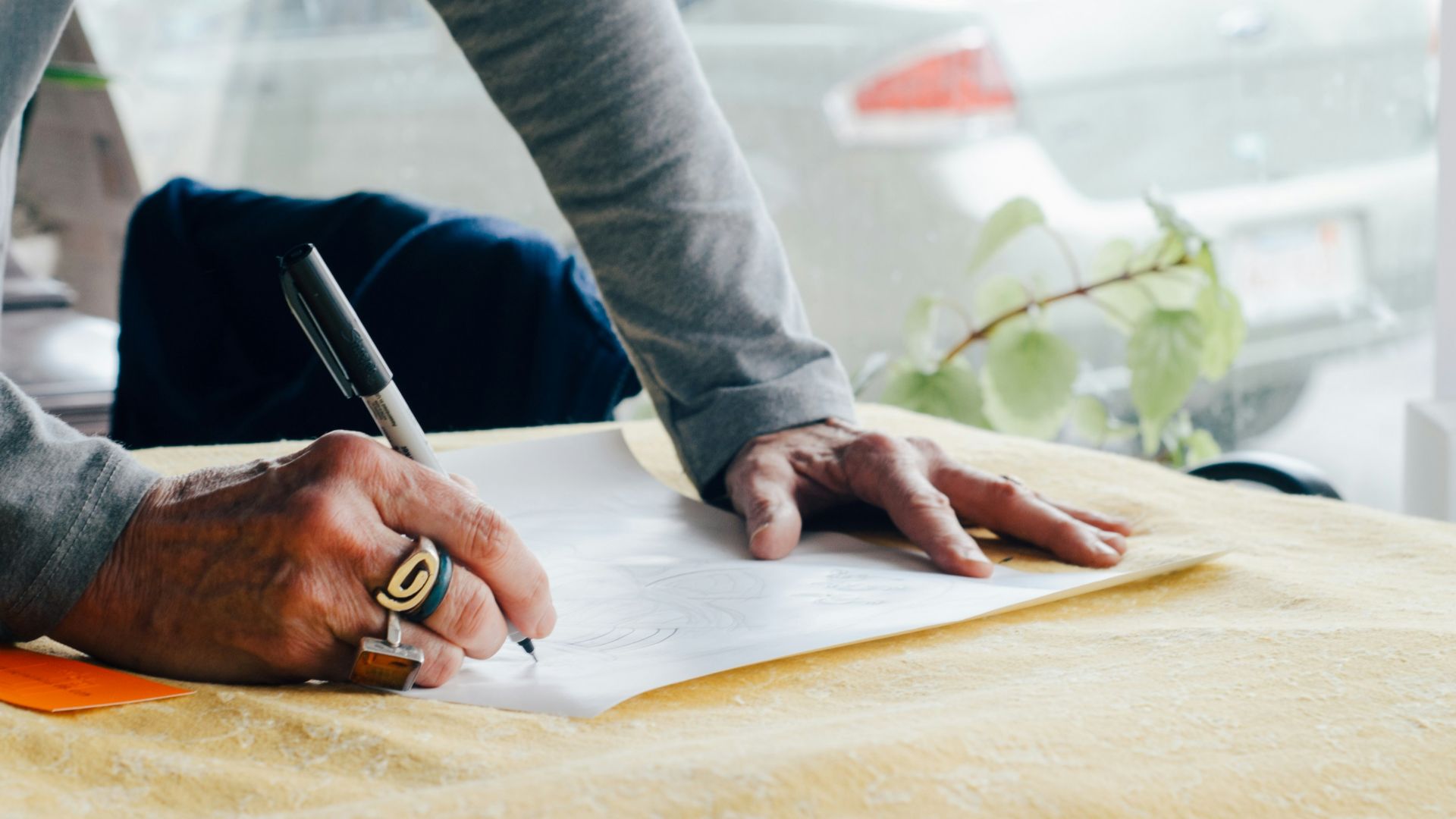 person writing on white plain paper on the table photography