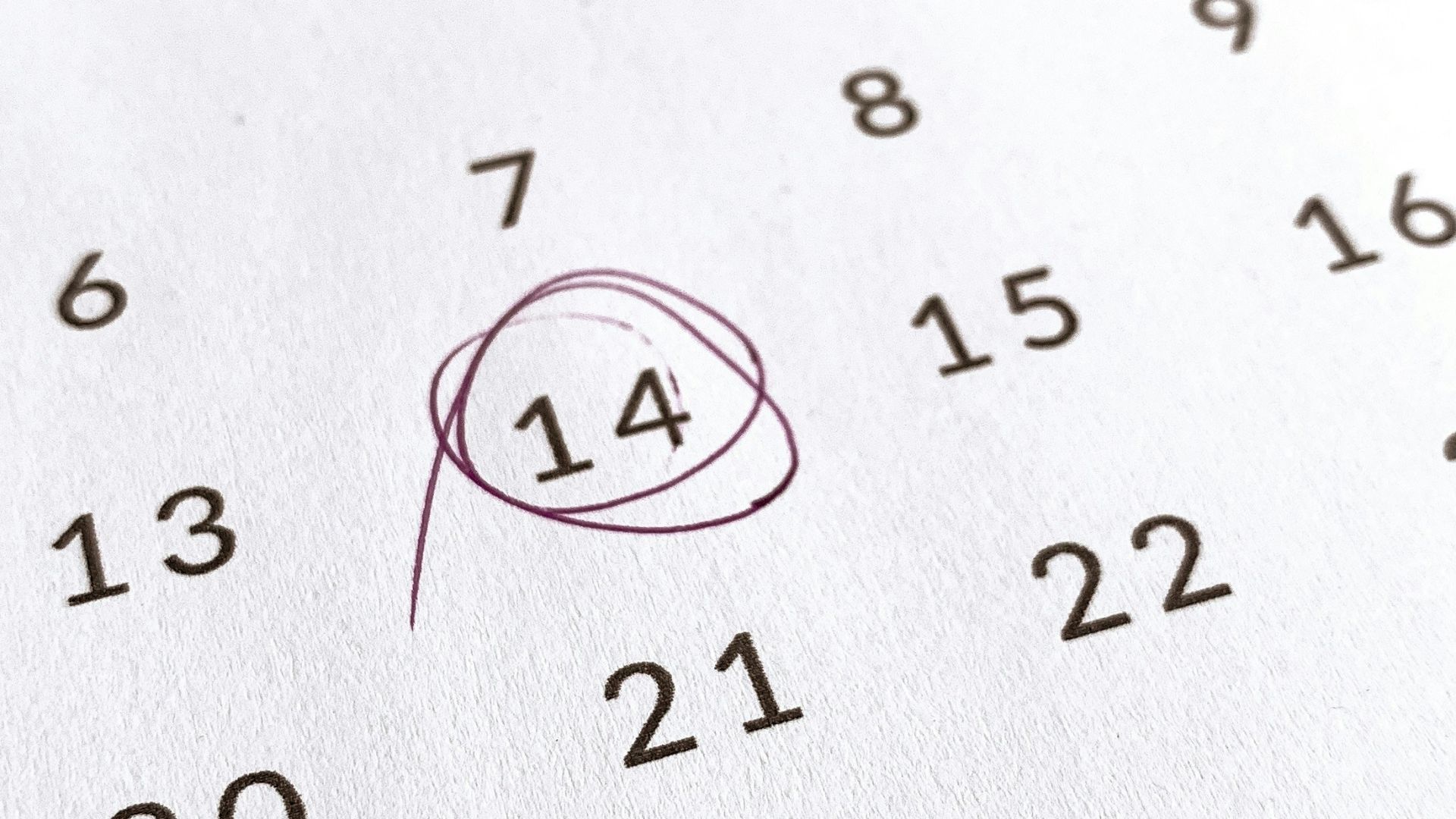 a close up of a calendar with a red marker