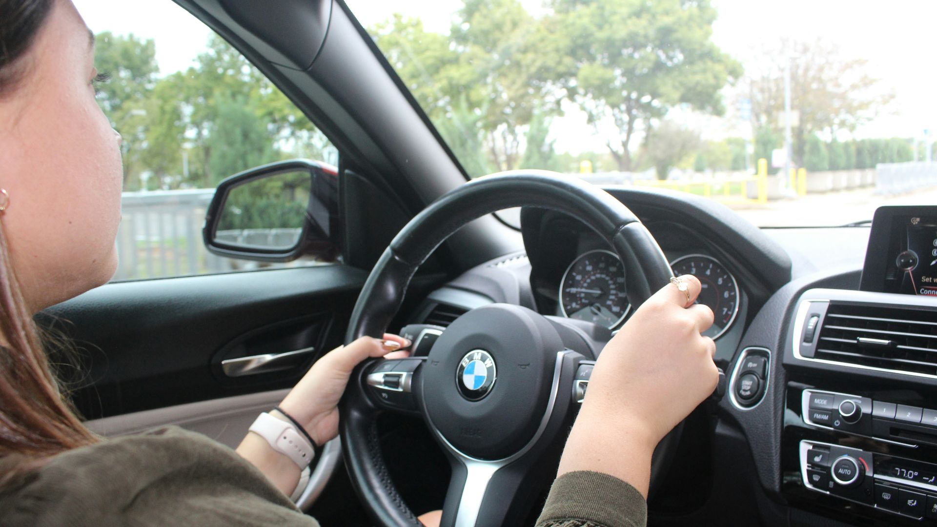 a woman driving a car with a steering wheel
