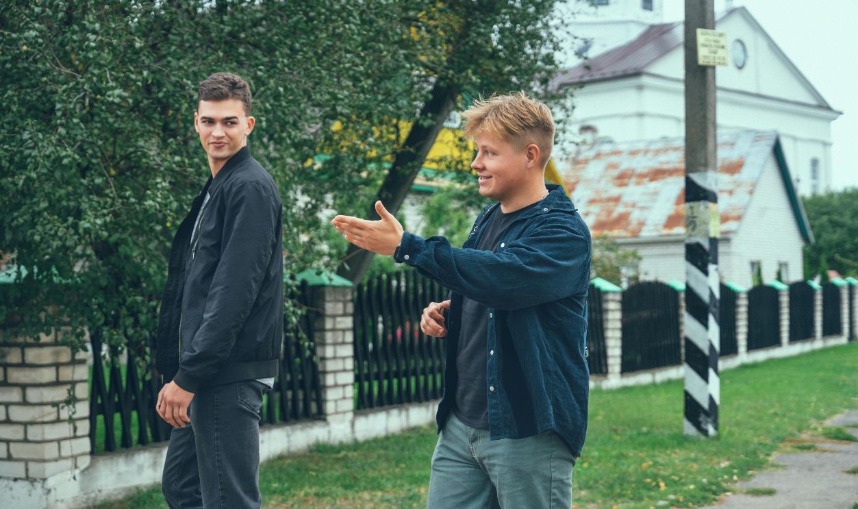 Two young men happily converse while strolling through a serene urban area