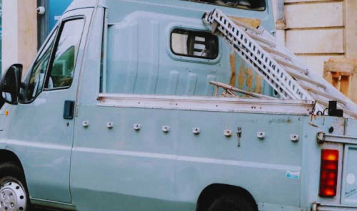 A vintage pickup truck parked on a charming city street with historic architecture
