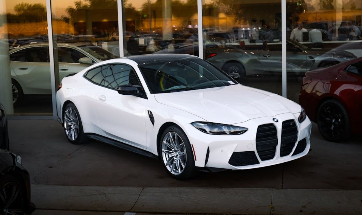 Modern white sports car showcased in a sleek showroom setting, highlighting its design.