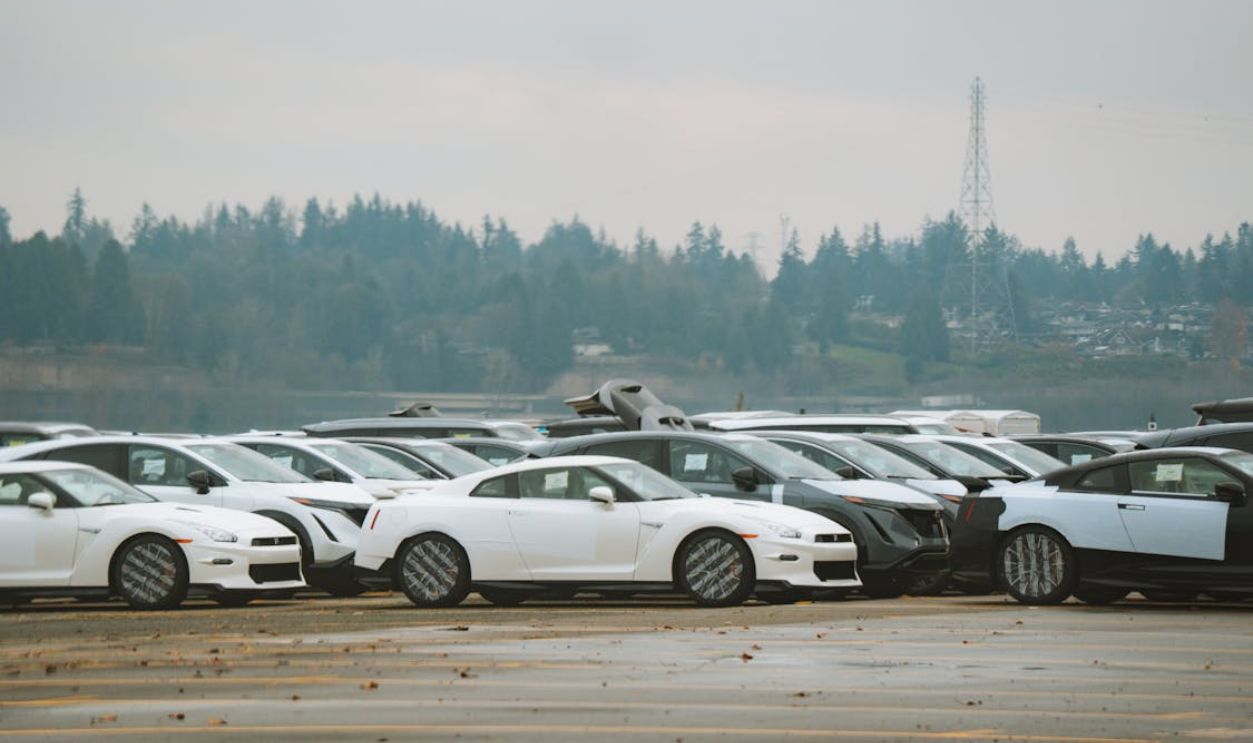 Wide shot of multiple sports cars parked outdoors on a cloudy day.