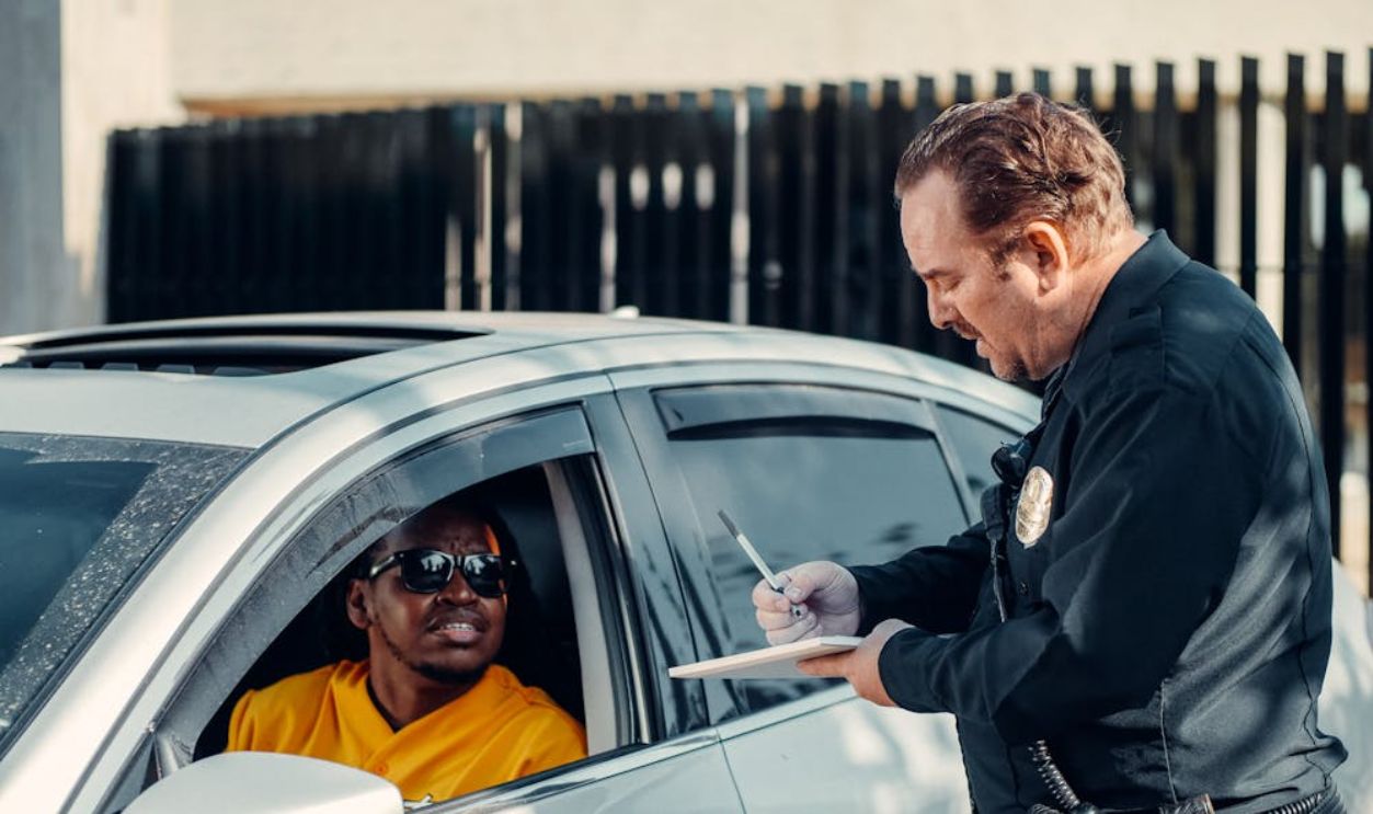 Police officer writes a traffic ticket for a driver during a routine stop.
