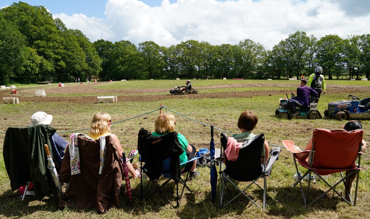 Spectators look on as competitors race in a heat during the World Lawnmower Championships, held by the British Lawn Mower Racing Association at Pondfield Farm, Alford, Surrey. 
