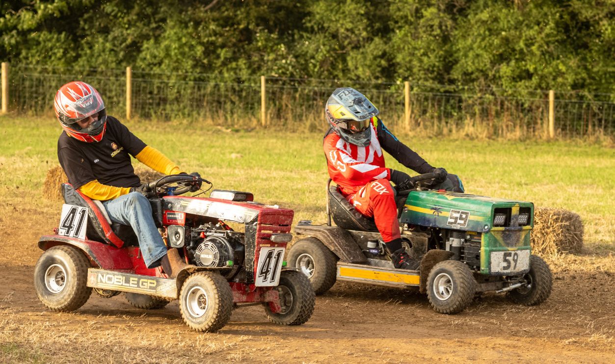 Racing lawn mower drivers grapple to keep control on a corner in the BLMRA 500, a Le Mans style 500 mile overnight lawn mower race in a field in West Sussex, UK. The British Lawn Mower Racing Association is holding its 50th anniversary endurance race with 52 teams, each with up to three drivers. 