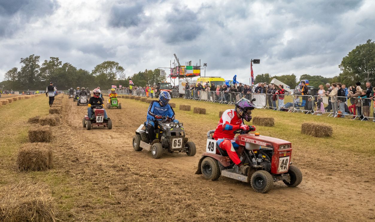 More than 50 racing lawn mowers are driven in a warm up lap in front of spectators before the start of the Le Mans style annual British Lawn Mower Racing Association endurance BLMRA 500 in Billingshurst, West Sussex, UK. 52 teams, each with up to three drivers raced their lawn mowers through the night 12/13 August 2023, each covering up to 500 miles. 