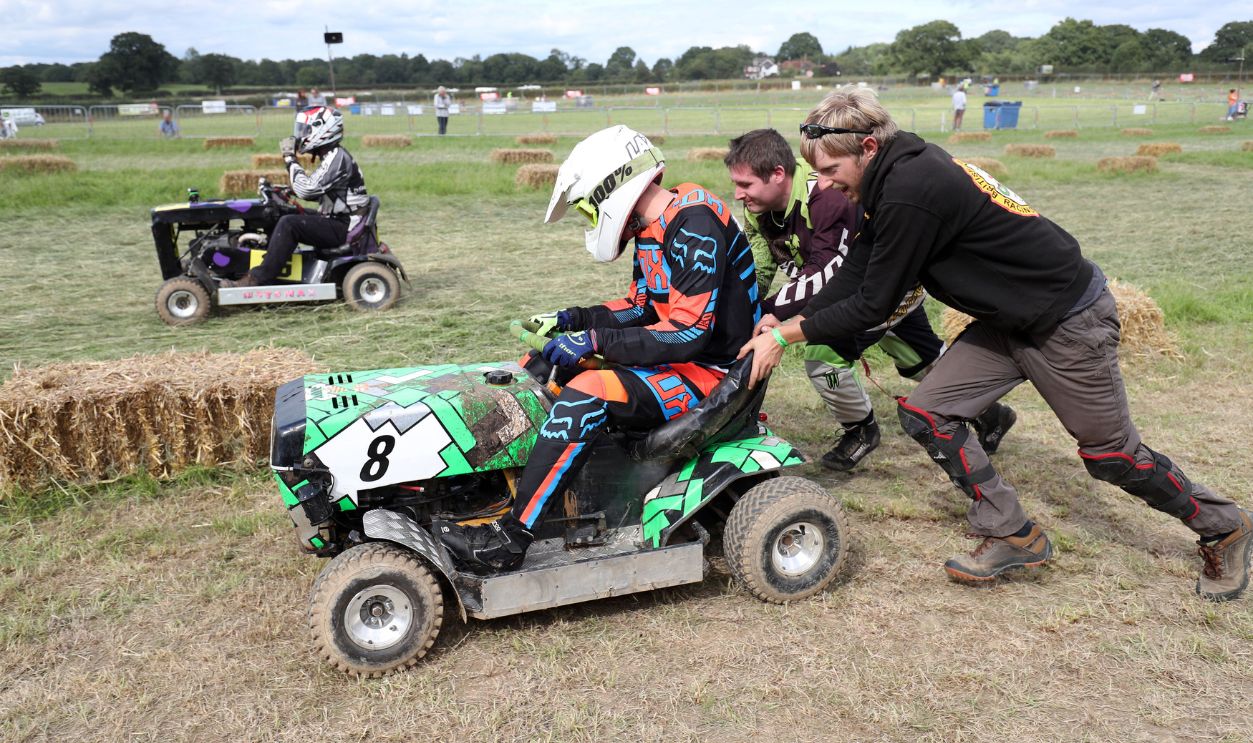 Members of the Nobby Racing team push one of their riders out from the pits during qualifying for the British Lawn Mower Racing Association 12 hour endurance race at Five Oaks near to Billingshurst in West Sussex. 