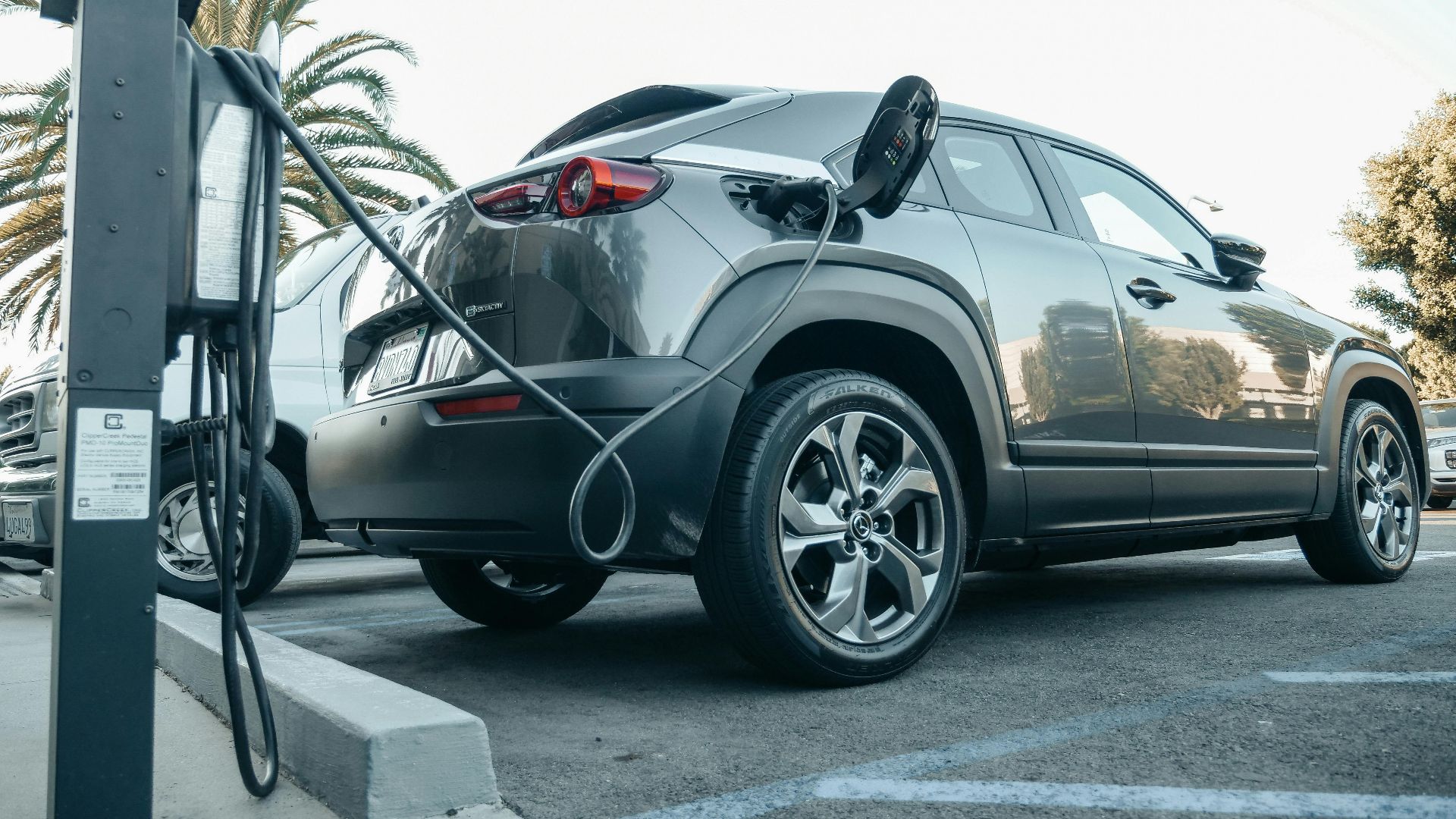 Modern electric vehicle charging at an outdoor station in daylight.