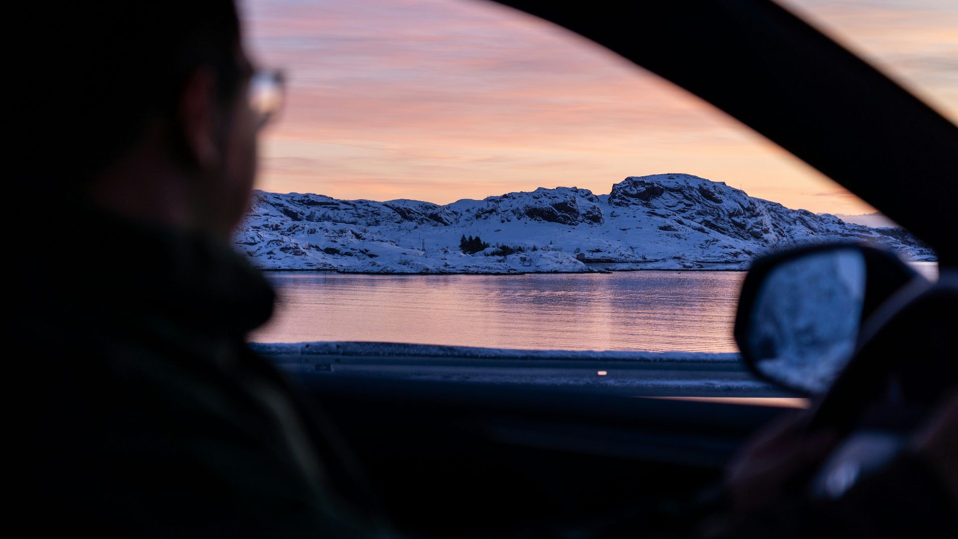 a man driving a car on a snowy road