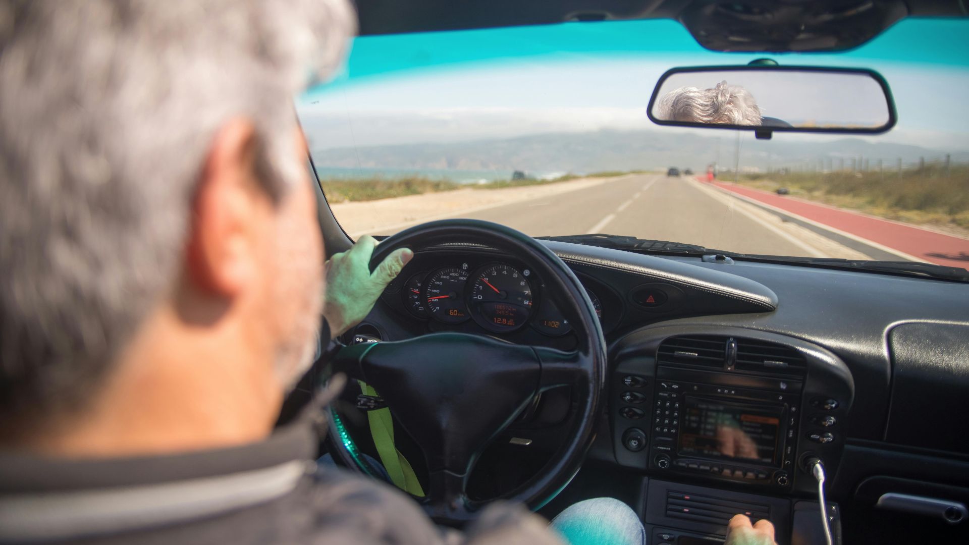 A person driving a car on a scenic highway in Portugal on a sunny day.