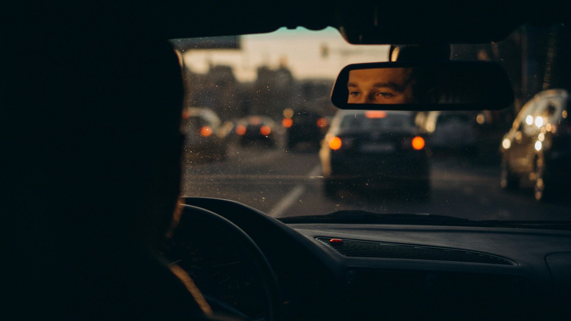 Capturing the reflection of a driver amidst evening traffic in Українка, creating a moody urban scene.