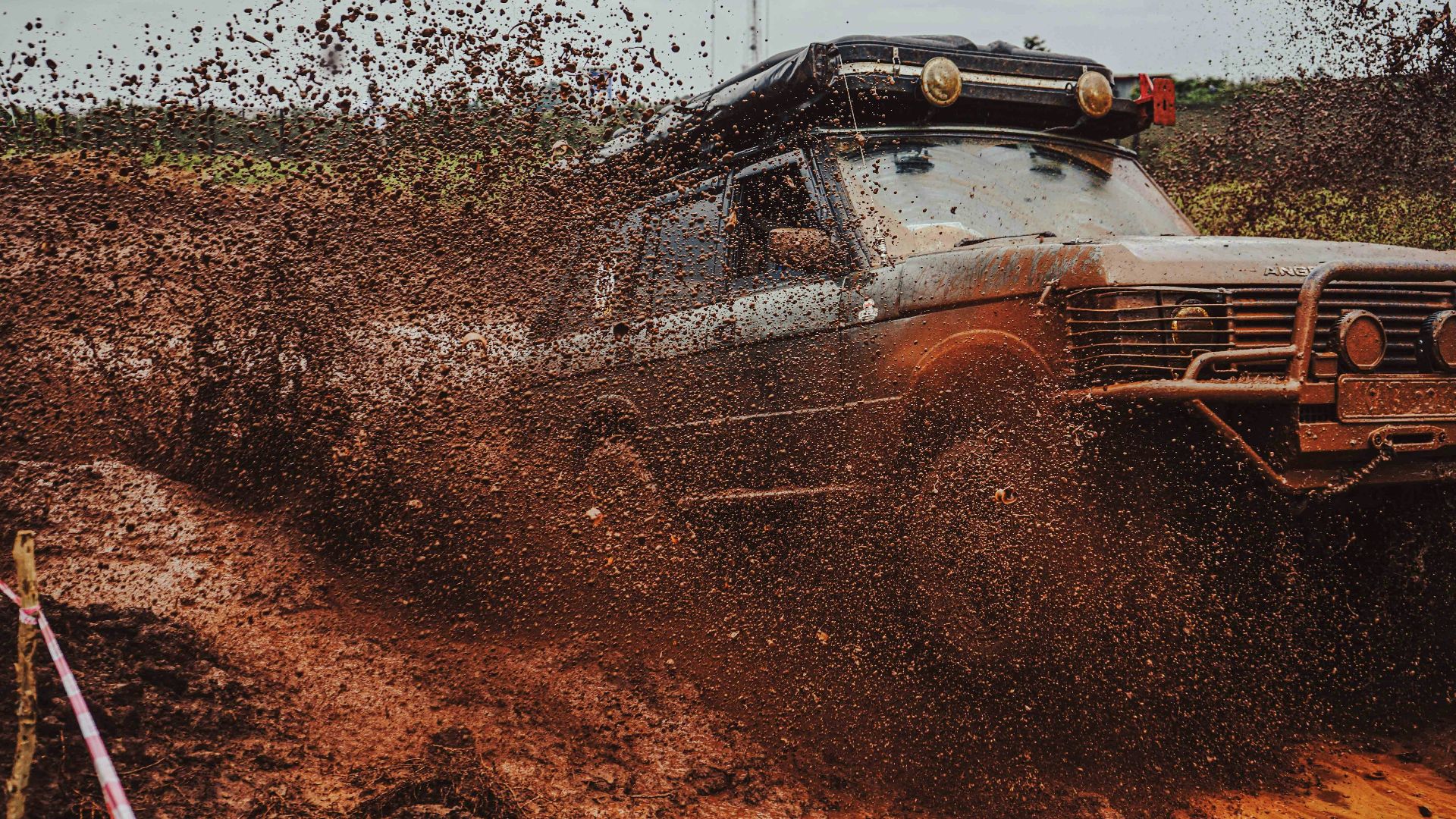 Off-road vehicle splashing through thick mud