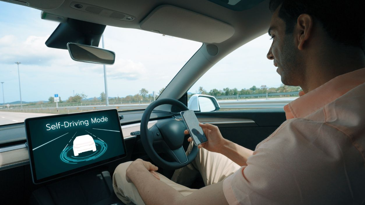 Shutterstock - 2420357917, Self driving car or autonomous vehicle travel on speed highway with driverless system and autopilot mode allowing man driver relax and focus on smartphone without compromising safety. Perpetual