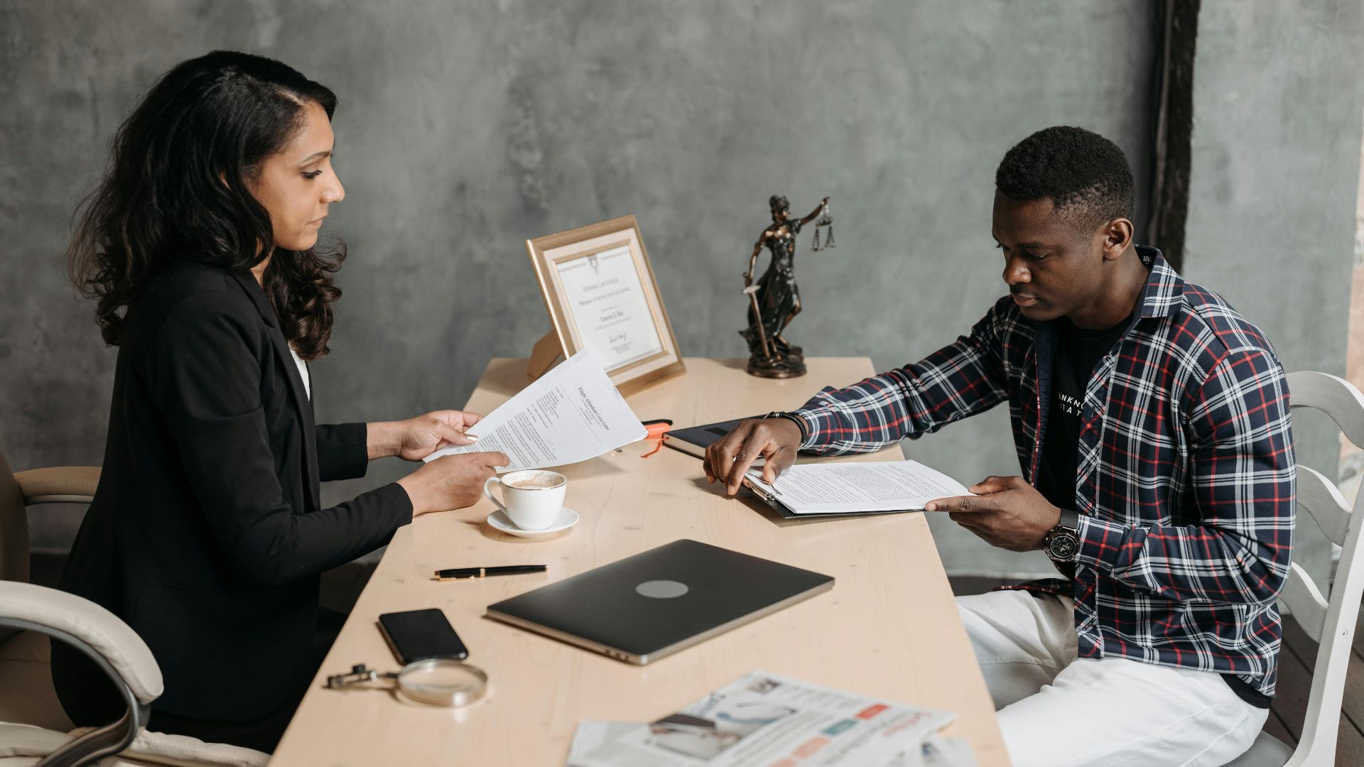 Business professionals discussing documents in a modern office setting.