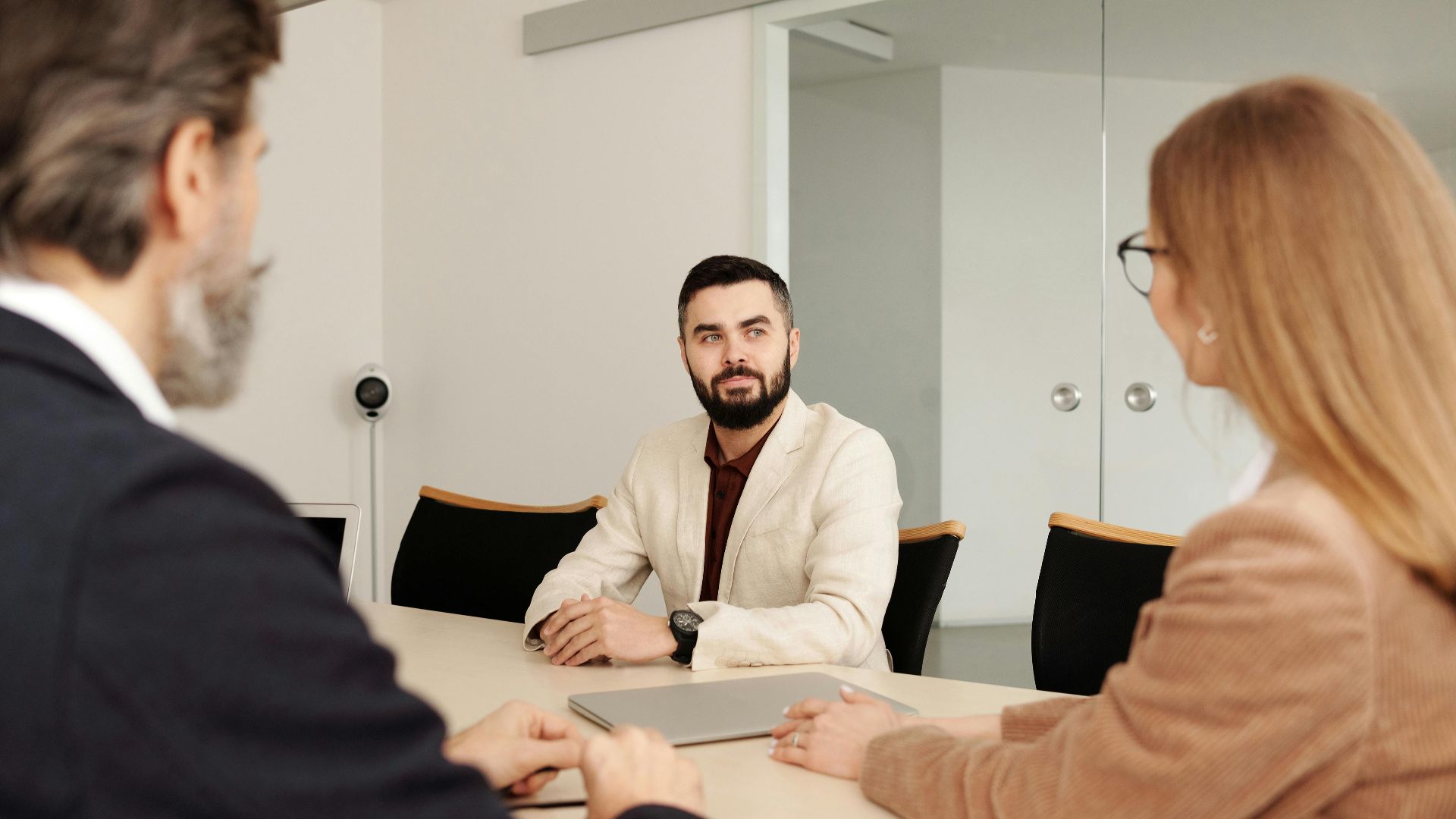 Professional business meeting with diverse team members in an office setting.