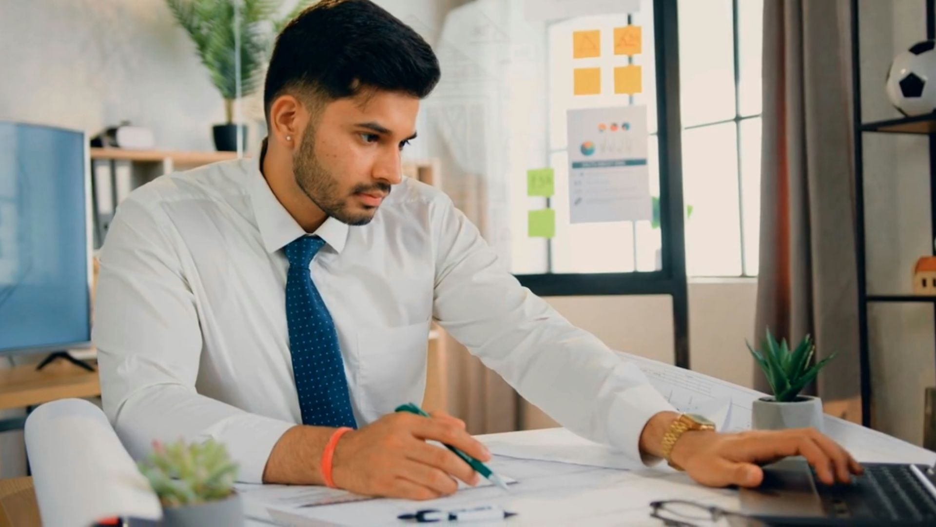a man sitting at a desk working on a laptop
