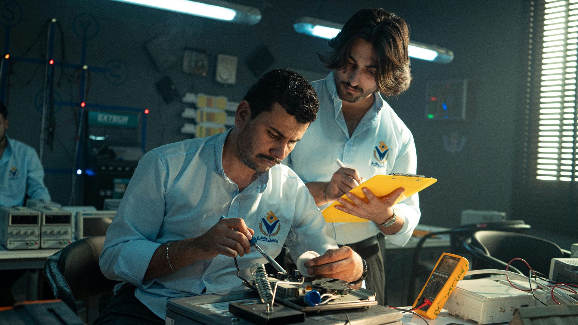 Focused technicians collaborate in an electronics lab, emphasizing teamwork and innovation.