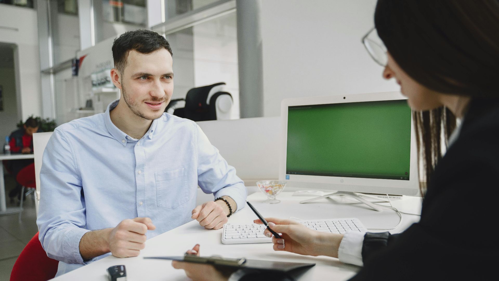A business meeting between two office professionals, discussing strategies in a modern office.