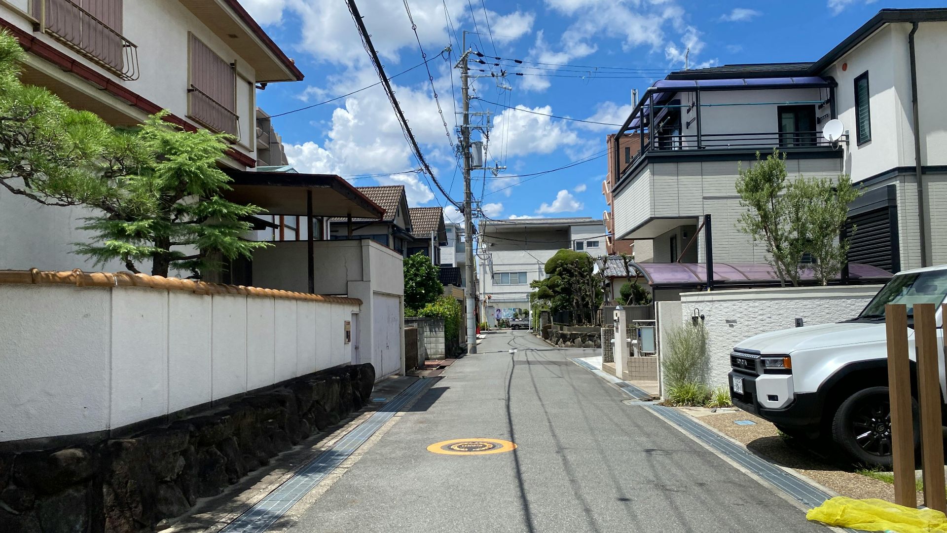 Sunny residential street in Osaka showcasing traditional and modern Japanese architecture.