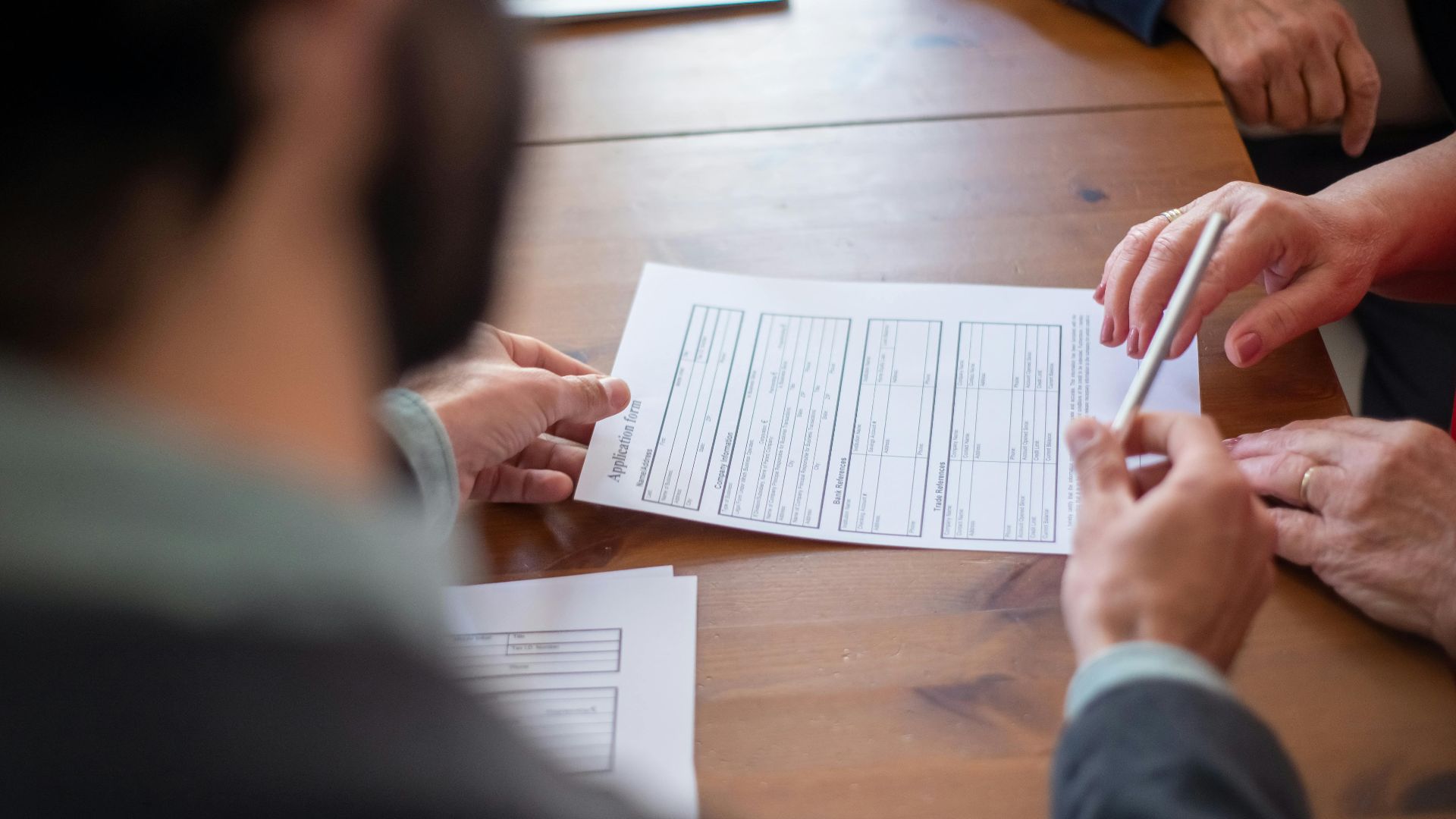 Close-up of business professionals reviewing documents at a meeting.