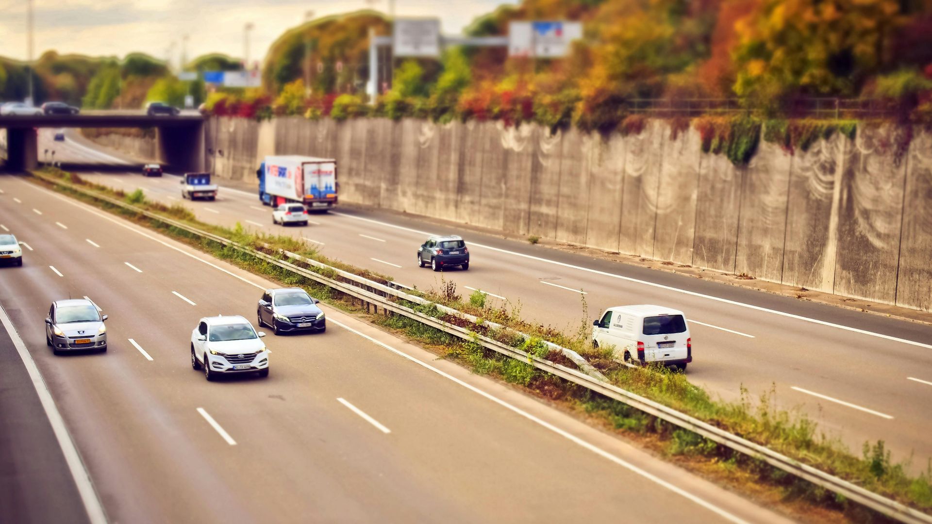 Cars and trucks moving on a highway under sunny skies, showcasing road travel.