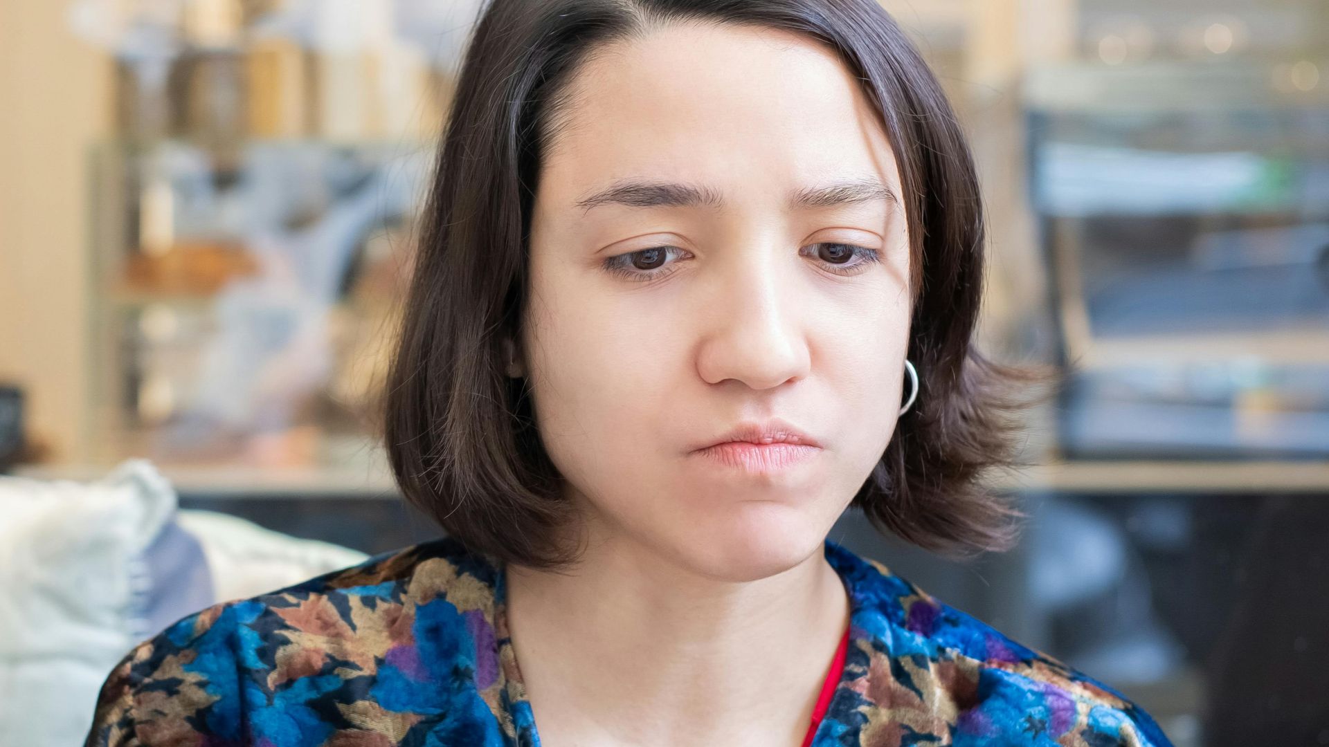 A woman intently working on her laptop in a cafe, captured indoors.