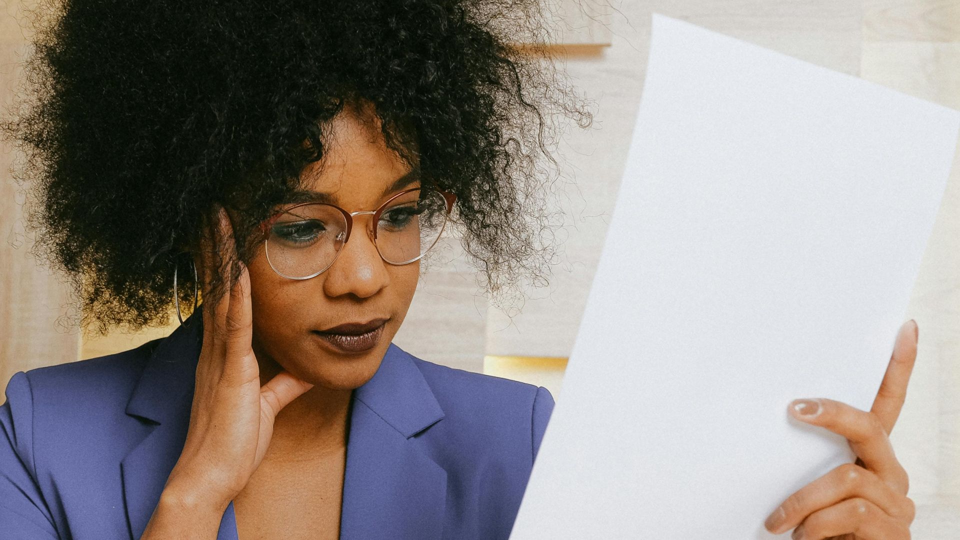 Businesswoman working on a laptop and reviewing a document at the office.