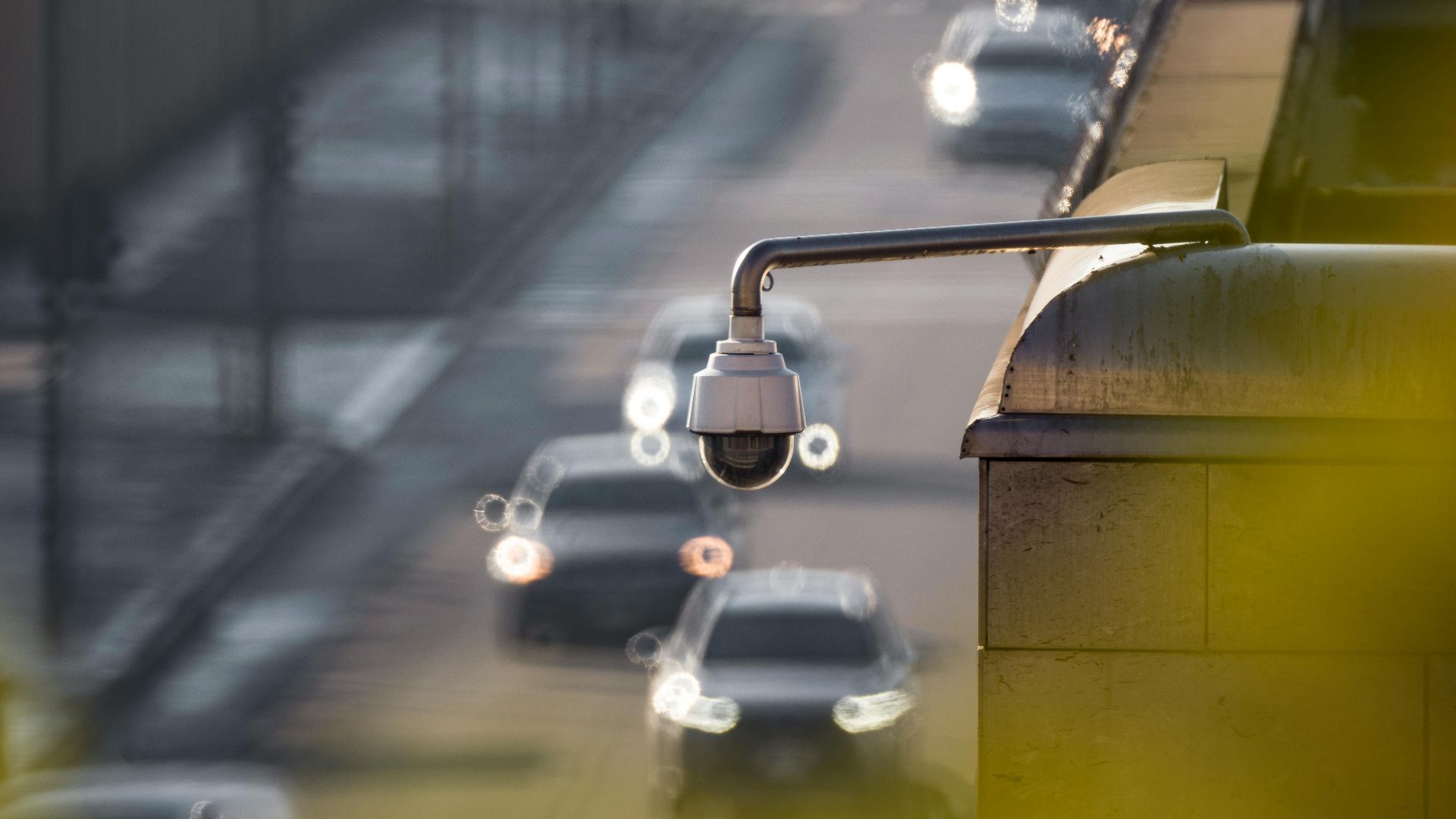 CCTV camera monitoring city traffic on a busy road with blurred vehicles in the background.