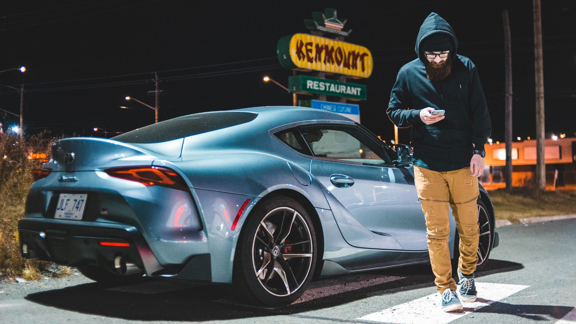man walking near gray coupe