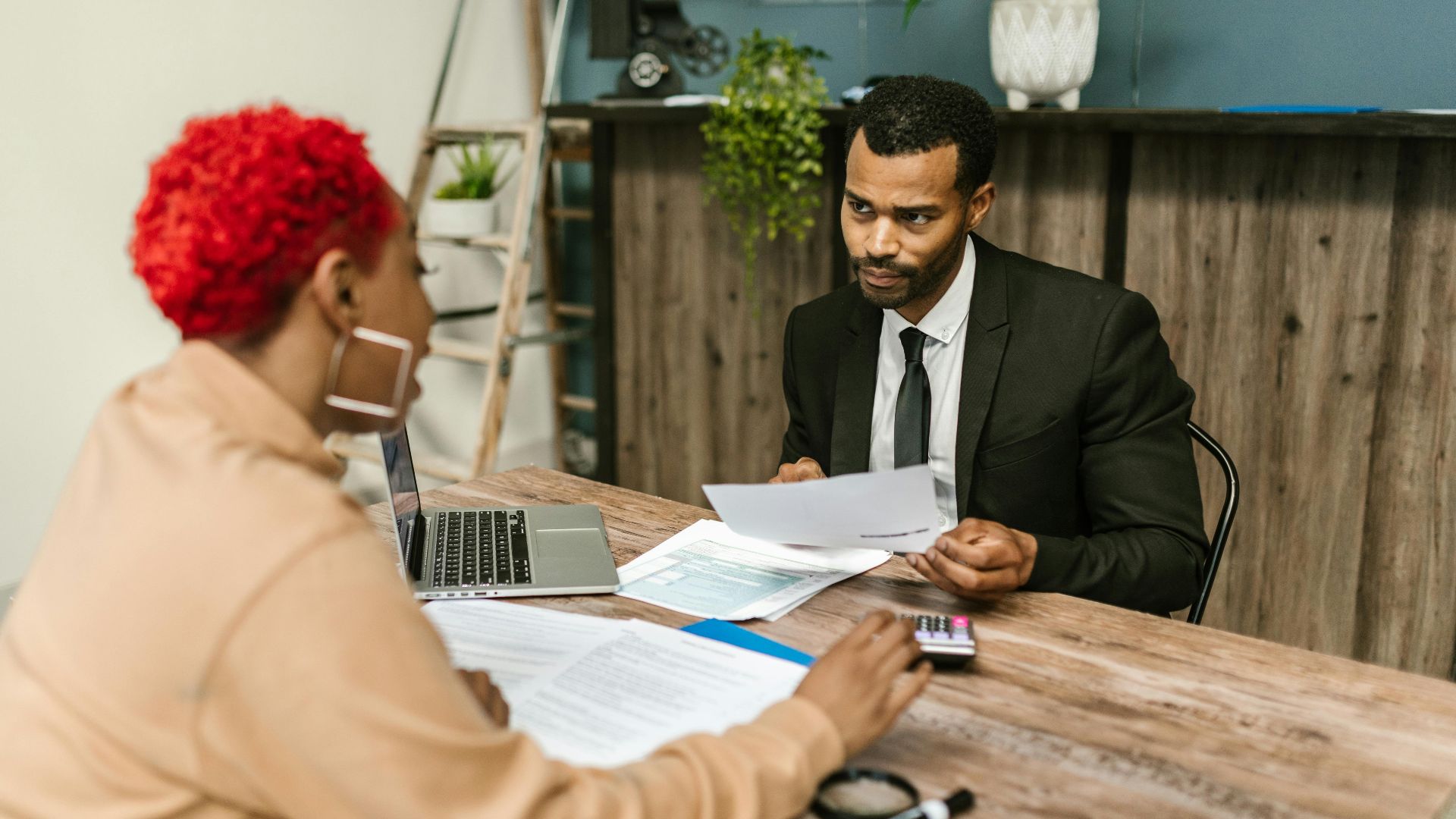 A discussion between two professionals focusing on financial documents in a modern office setting.