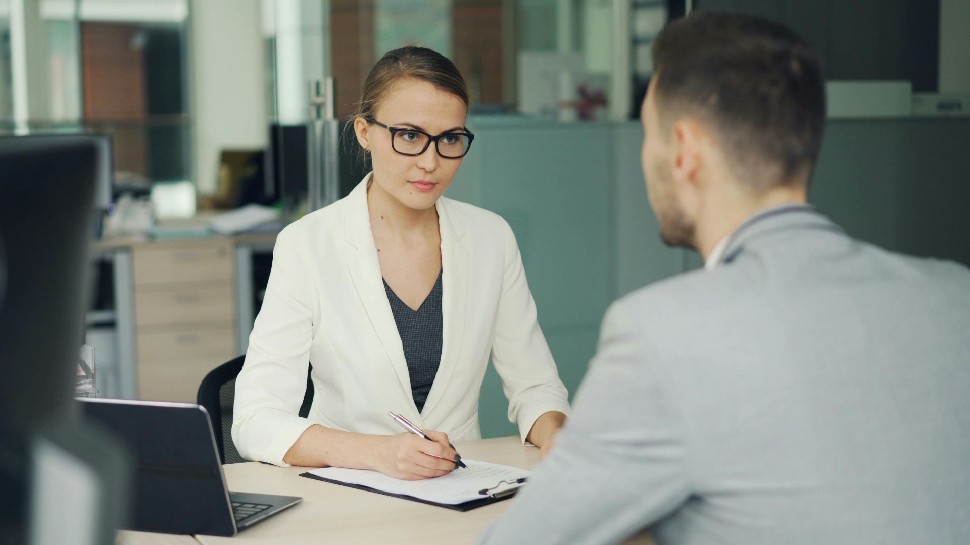 Two professionals in a serious business meeting at a modern office setting.