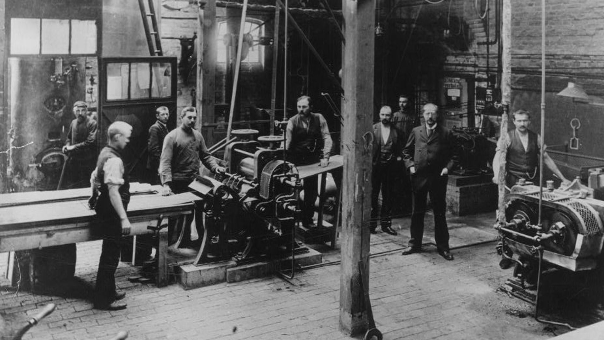 Workers posing around conveyor belt in Berliner's gramophone plant, Hanover, Germany