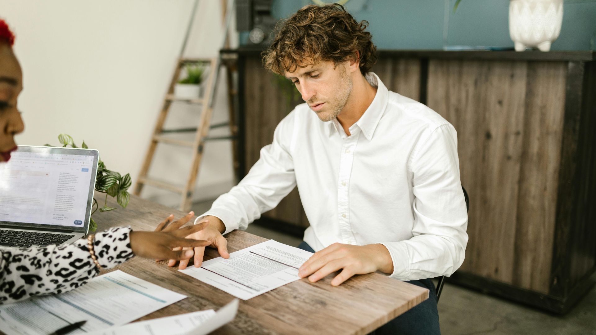 Two professionals discussing financial documents in an office setting.
