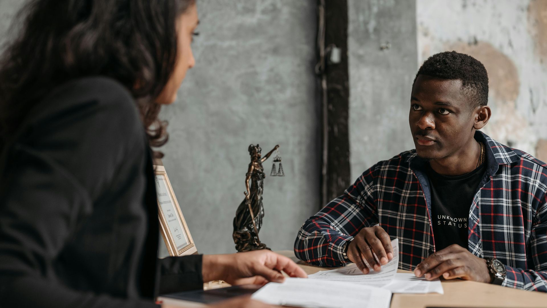 Business meeting between a lawyer and client in a professional office setting.