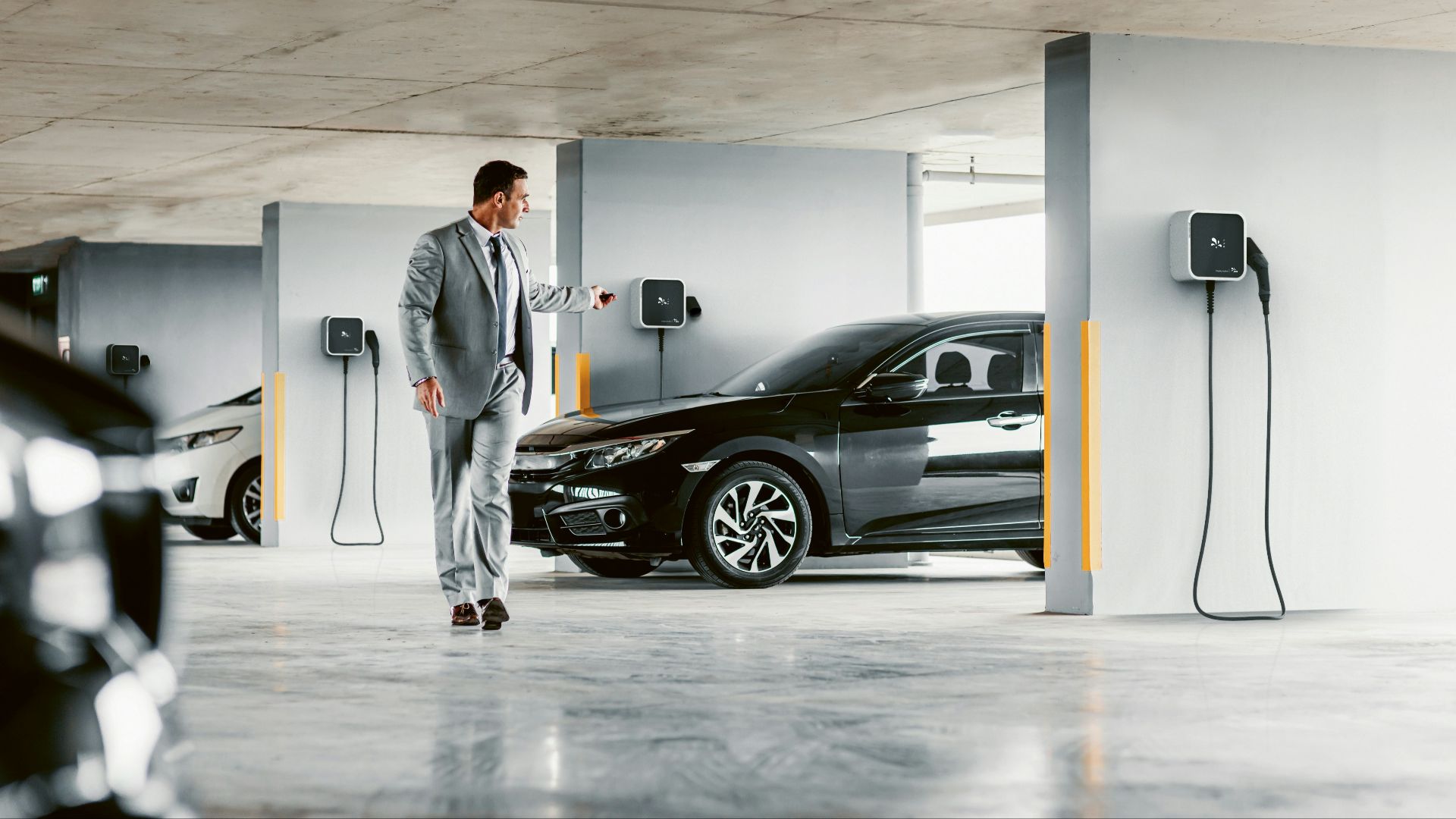 A man in a suit walking towards a car