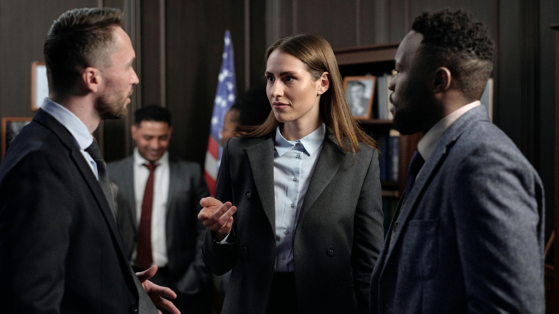 A diverse group of business professionals engaged in a discussion in an office.