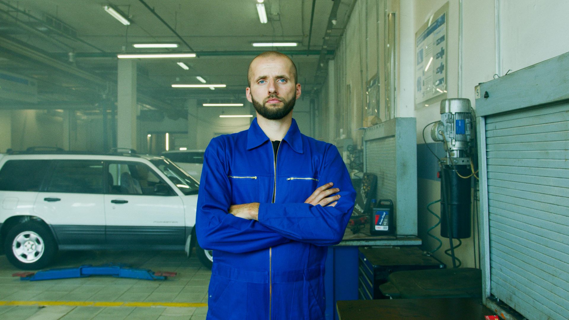 Professional mechanic in a repair shop, focused on car maintenance and vehicle service.